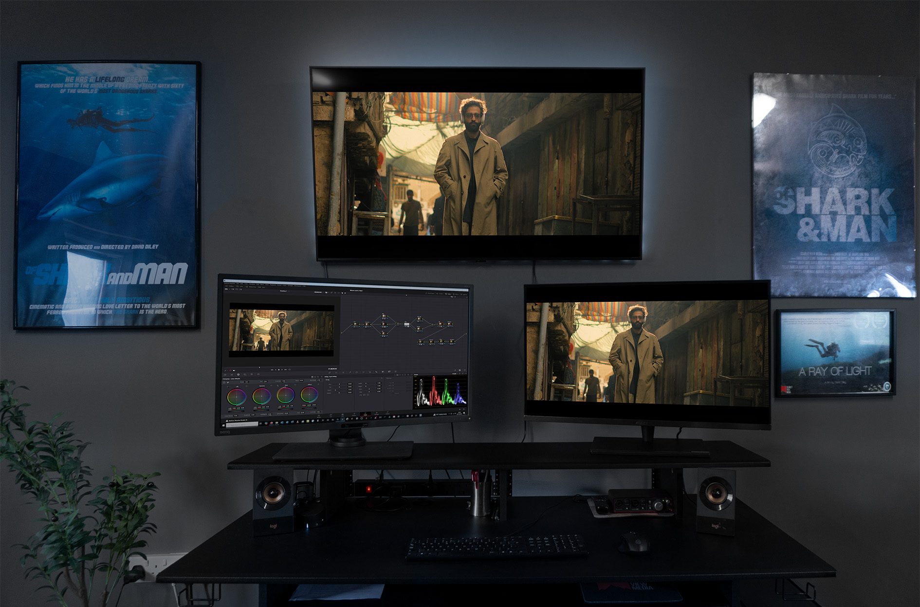 Editor at an Astra Visual Studios edit and colour grading suite, with reference monitors and posters of past projects